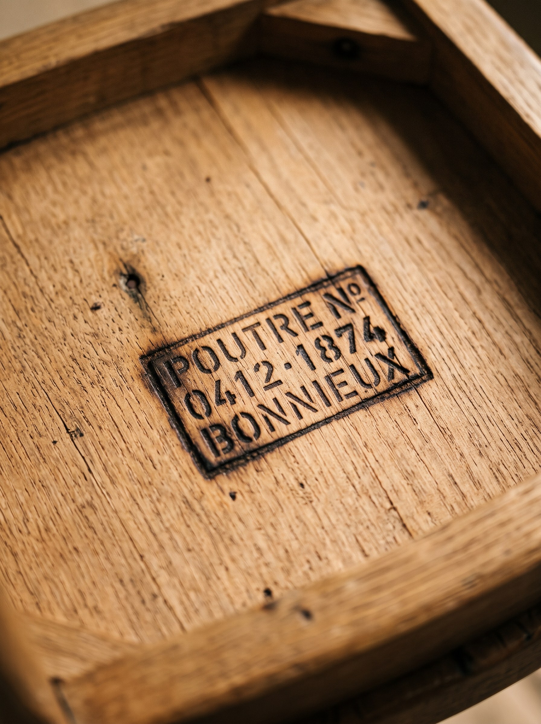 Underside of a piece with the beam number, year and village burnt into the oak